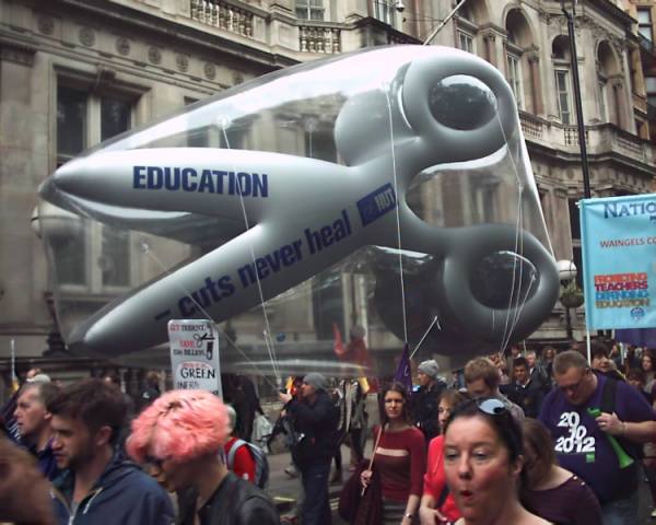Giant inflatable scissors with slogan 'education cuts never heal'